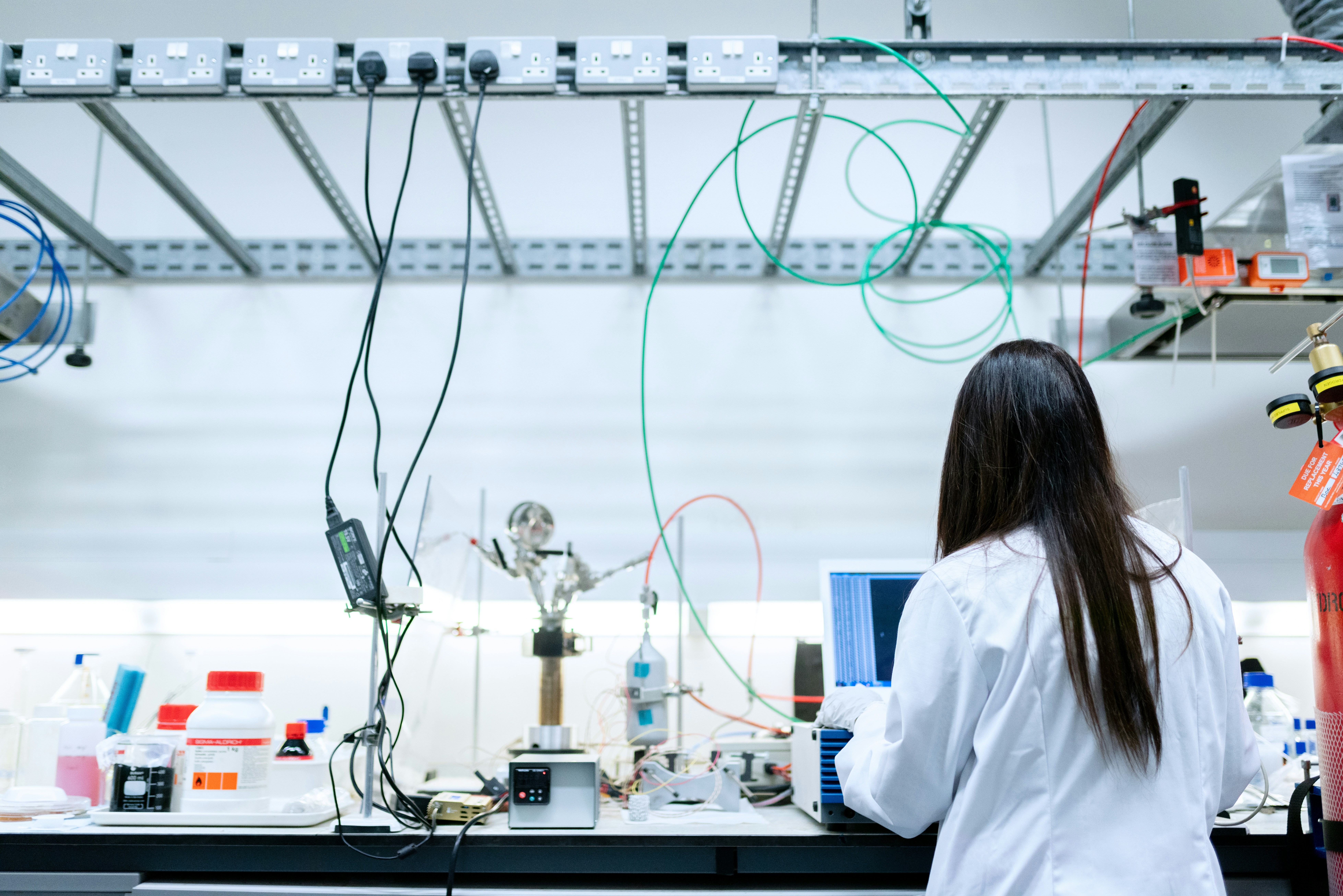 Researcher in a lab coat working at a computer in a laboratory